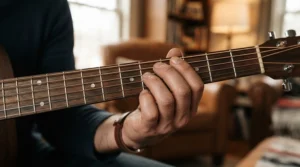 Close-up of fingers effortlessly reaching across the fretboard of a short-scale bass guitar for small hands